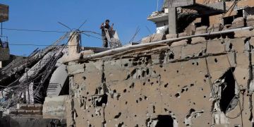 Ein Mann räumt Trümmer aus seinem Haus in Syrien.