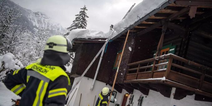 Die Einsatzkräfte sind vor allem damit beschäftigt, einsturzgefährdete Dächer vom Schnee zu befreien. Feuerwehrleute versuchen die Schneemassen von Dächern zu entfernen.