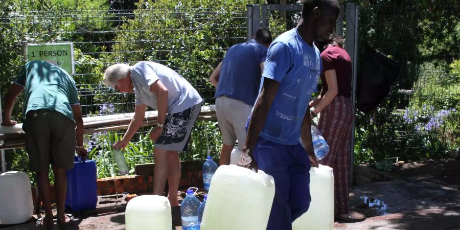 Bürger füllen Wasserkanister an einer natürlichen Quelle in Kapstadts Vorort Newlands auf.