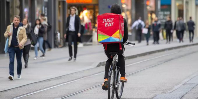 Arbeit mit und auf dem Velo: Ein Velokurier von Eat.ch ist in Genf unterwegs. Velo Kurier Genf
