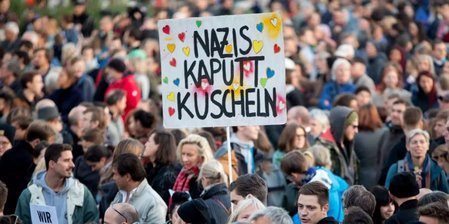 Menschen nehmen an einer Demonstration auf dem Ballhausplatz in Wien teil.