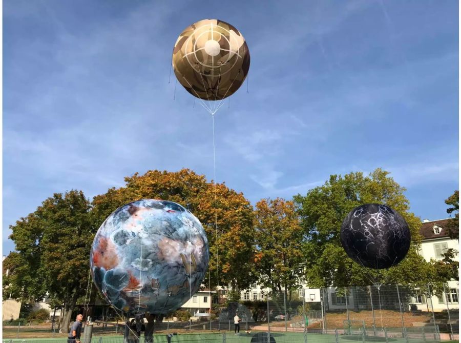 Die Planeten scheben. Der in der Mitte ist vom Basler Künstler Enrique Fontanilles, der links unten vom Franzosen Michel Blazy  und der rechts vom Basler Hanspeter Hoffmann.