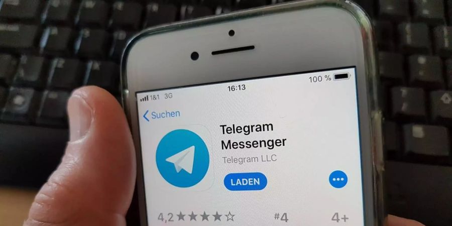 Ein Mann lädt die App Telegram Messenger aus dem AppStore herunger.