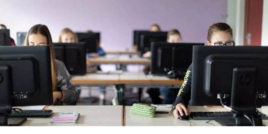 Gymnasiasten sitzen in einem Informatikzimmer vor den Computern.