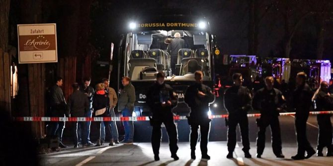 Polizisten stehen nach dem Anschlag vor dem Mannschaftsbus des BVBs.