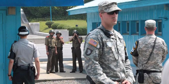 Nordkoreanische Soldaten schauen auf die Südseite der Grenze, während südkoreanische (l.) und US-amerikanische (r.) Soldaten an der entmilitarisierten Zone um Panmunjom (PRK) Wache stehen. Nordkoreanische Soldaten schauen auf die Südseite der Grenze, während südkoreanische (l.) und US-amerikanische (r.) Soldaten an der entmilitarisierten Zone um Panmunjom (PRK) Wache stehen.