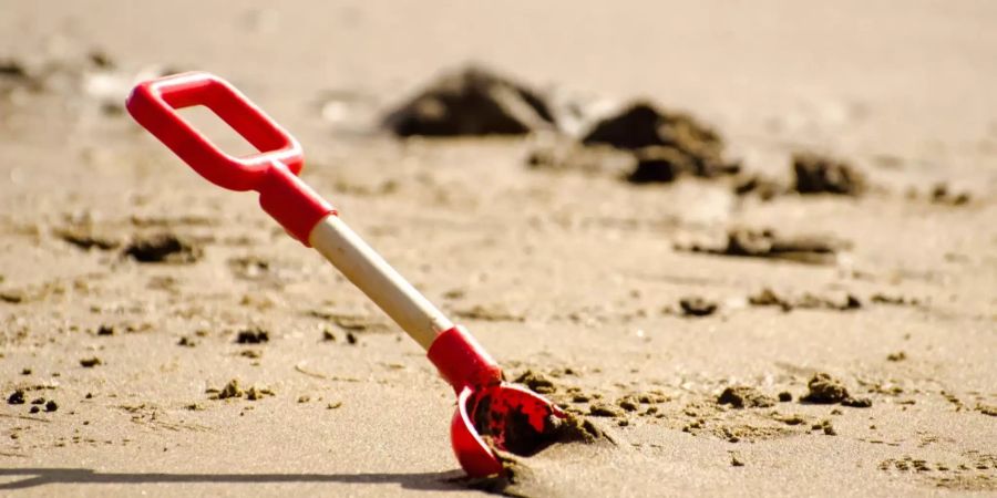 Eine Schaufel steckt im Sand (Symbolbild).