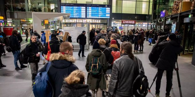 Reisende stehen im Berliner Hauptbahnhof und werden über den Streik informiert. Reisende stehen im Berliner Hauptbahnhof und werden über den Streik informiert