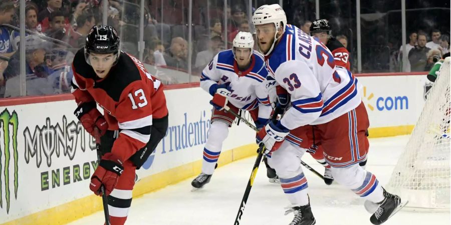 Nico Hischier von den New Jersey Devils behauptet den Puck gegen Fredrik Claesson von den New York Rangers.