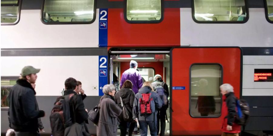 In Bern steigen Reisende in einen Doppelzug nach Biel ein.