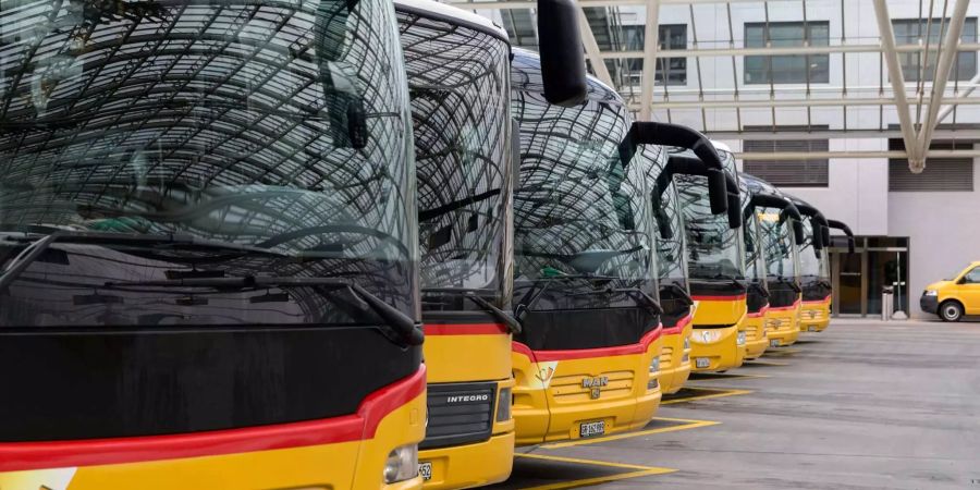 Postautos stehen auf einem Parkplatz.