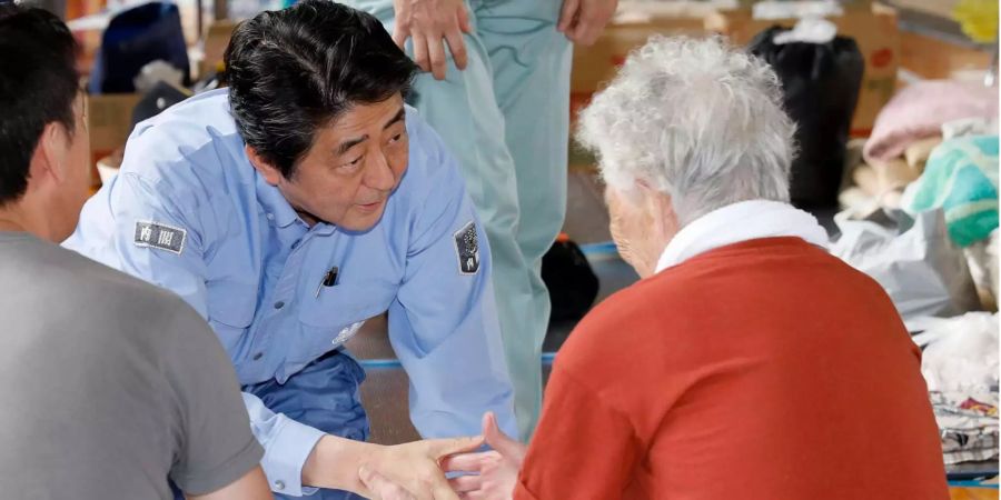 Der japanische Ministerpräsident Shinzo Abe besucht Menschen in Notunterkünften.