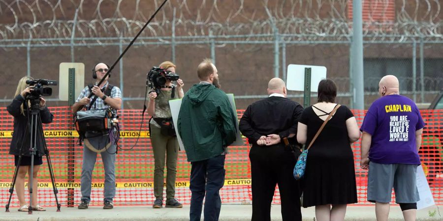 Demonstranten stehen vor dem Nebraska State Gefängnis und werden dabei von Journalisten gefilmt.