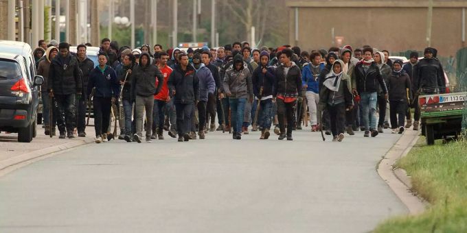 Mit Stöcken bewaffnete Migranten in den Strassen von Calais. Mit Stöcken bewaffnete Migranten in den Strassen von Calais.