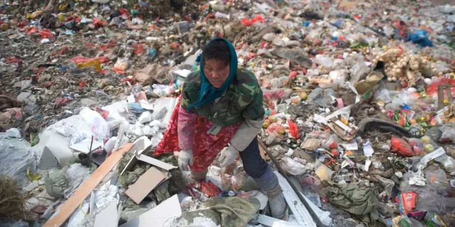 Eine Frau sammelt Abfall in China.