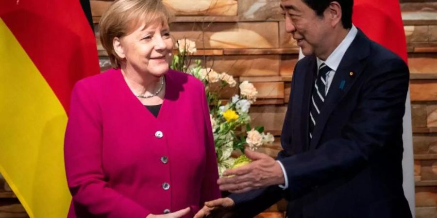 Angela Merkel wird von Shinzo Abe begrüsst. Foto: Kay Nietfeld