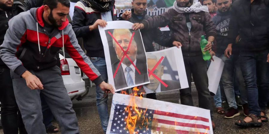 Palästinenser verbrennen als Protest gegen die Anerkennung Jerusalems als Hauptstadt von Israel US-Flaggen und demonstrieren mit Bildern von Trump und Netanjahu.