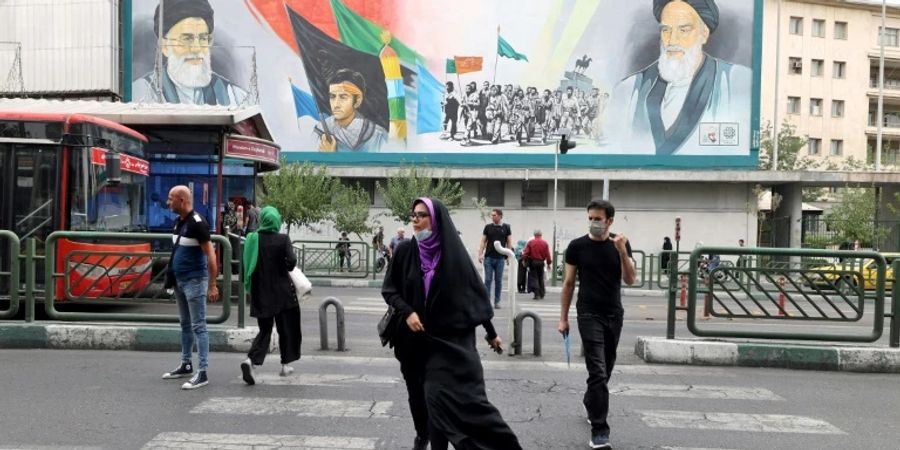Iraner vor einem Poster mit Ayatollah Khomeini