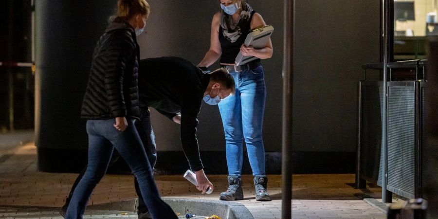 Polizisten sichern Spuren am Tatort im Aussenbereich eines Fast-Food-Restaurants in Oberhausen.