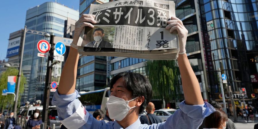 Ein Mann verteilt in Tokio eine Sonderausgabe der Zeitung Yomiuri, in der über die jüngsten Raketenstarts Nordkoreas berichtet wird.