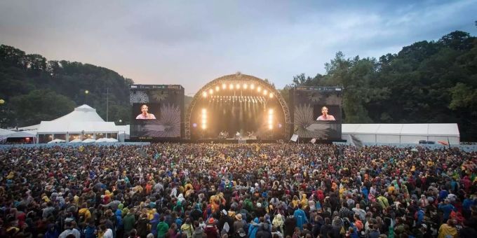 Menschen stehen Schulter an Schulter vor einer Bühne an einem Openair. openair coronavirus