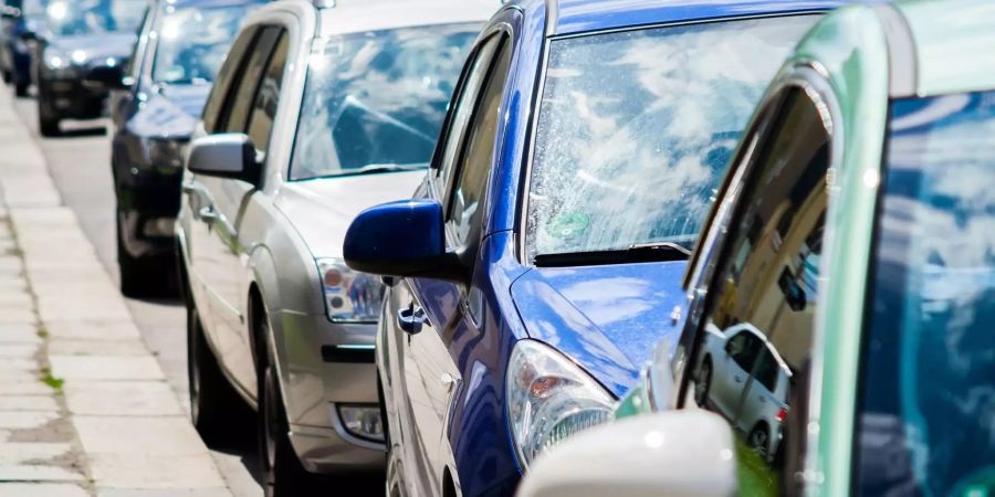 Parkende Autos auf einer Strasse.