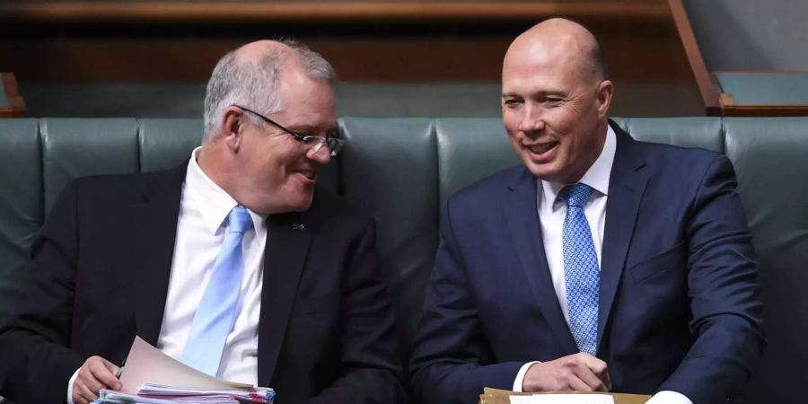 Der bisherige Schatzmeister Australiens und Neu-Premierminister Scott Morrison (l.) spricht mit seinem Gegenkandidaten und ehemaligen Innenminister Peter Dutton während einer Fragestunde im Parlament in Canberra (AUS).