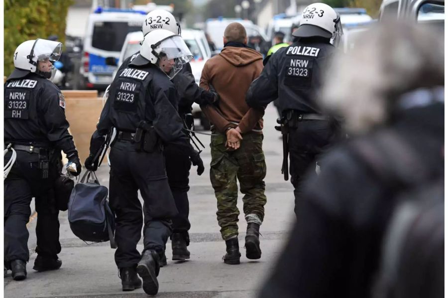 Polizisten führen einen Aktivisten aus einem der besetzten Häuser in Manheim (D) ab.