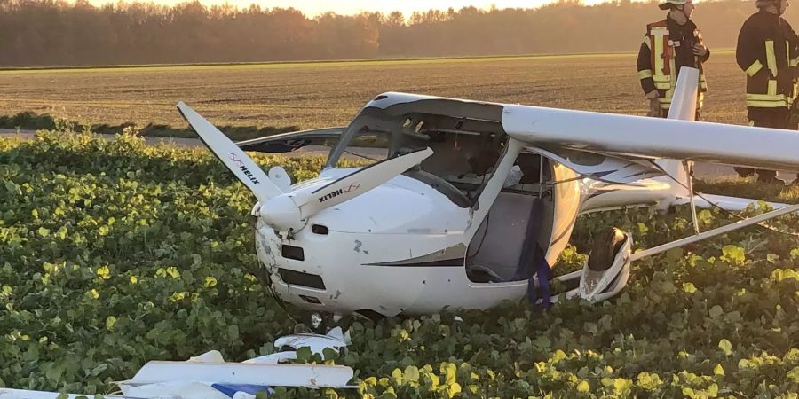 Ein beschädigtes Leichtflugzeug liegt auf einem Acker.