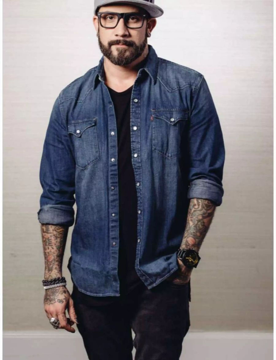 Backstreet Boy AJ McLean posiert 2015 in Jeanshemd und schwarzer Hose.