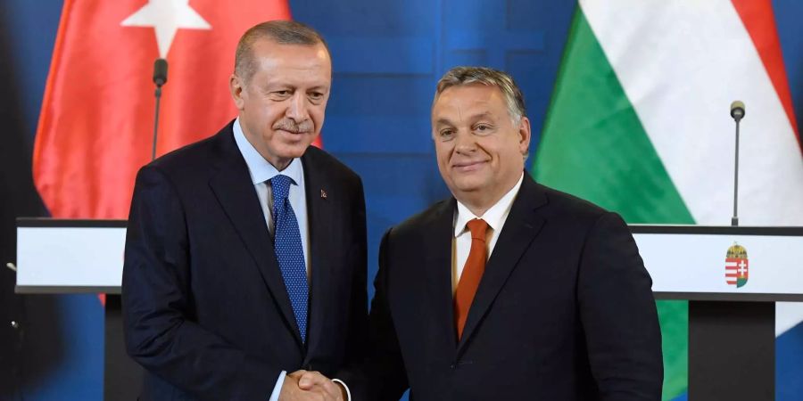 Der türkische Präsident Recep Tayyip Erdogan (l.) und der ungarische Premierminister Viktor Orban (r.) schütteln sich während einer Pressekonferenz vor einer gemeinsamen Sitzung im Parlamentsgebäude in Budapest die Hände.