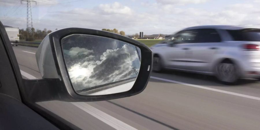 Sicht aus Beifahrerfenster eines Autos auf ein überholendes schnelles Auto - Keystone