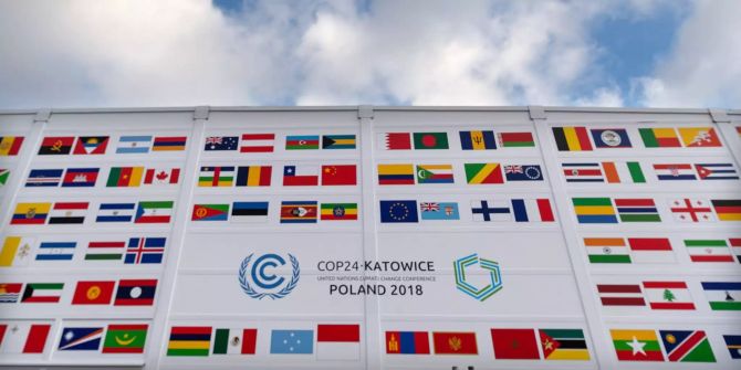 Fahnen diverser Länder und das Logo der Klimakonferenz der Vereinten Nationen COP24 sind an der Fassade am Veranstaltungsort angebracht.