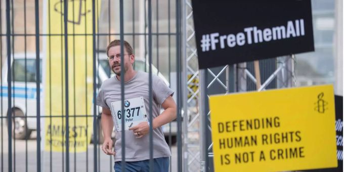 Ein Menschenrechtsaktivist, läuft den Berliner Marathon in einer symbolischen Nachbildung eines türkischen Gefängnishofes mit. Ein Menschenrechtsaktivist, läuft den Berliner Marathon in einer symbolischen Nachbildung eines türkischen Gefängnishofes mit.