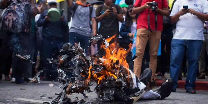 Demonstranten zünden eine Figur, die den Präsidenten von Guatemala, Morales, symbolisiert, während eines Protests gegen die Regierung an. Demonstranten zünden eine Figur, die den Präsidenten von Guatemala, Morales, symbolisiert, während eines Protests gegen die Regierung an.