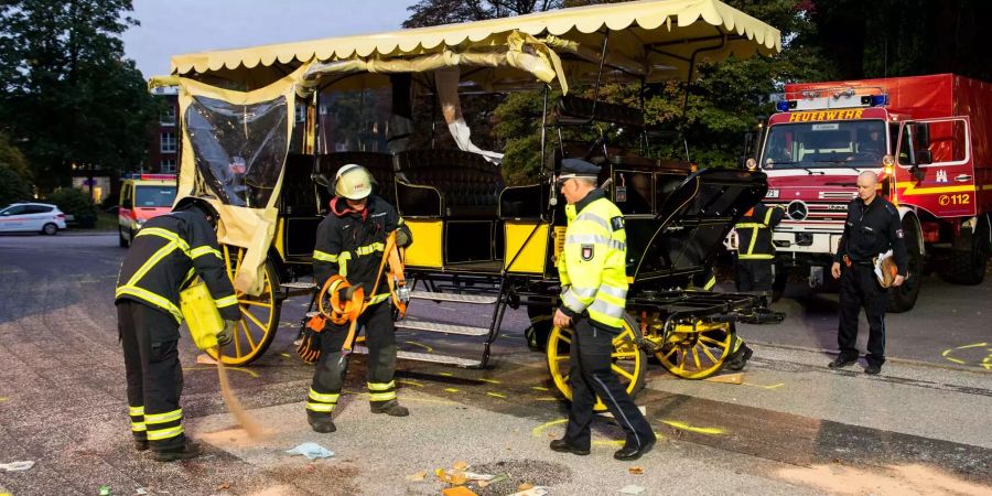 Einsatzkräfte der Feuerwehr sichern nach einem Unfall mit einer Pferdekutsche auf dem Friedhof Ohlsdorf den Unfallort.