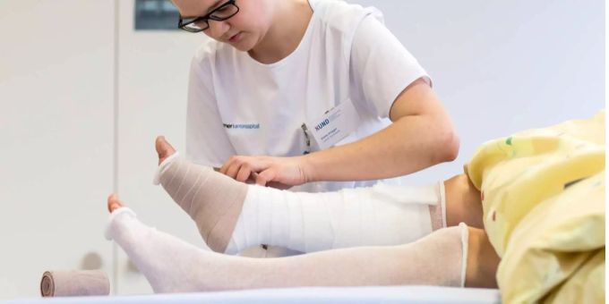 Eine Pflegerin wechselt den Verband. (Symbolbild) Pflege Beruf Grosser Rat