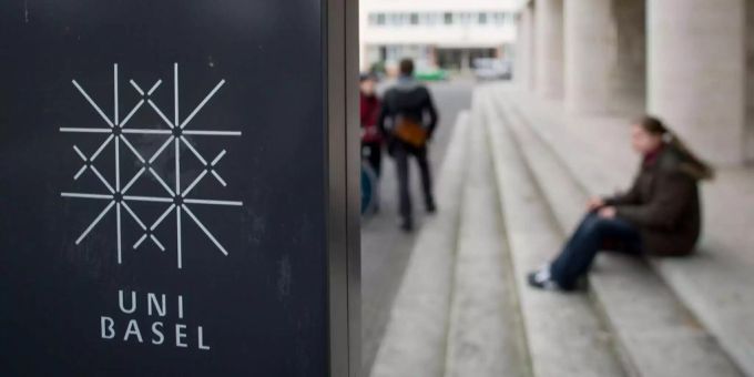 Personen sitzen am Eingang der Universität Basel. Personen sitzen am Eingang der Universität Basel.