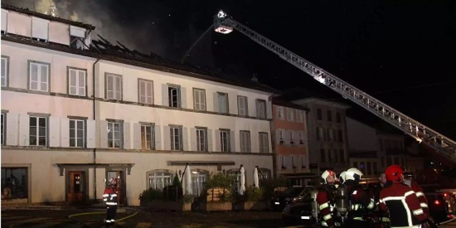 Feuerwehrleute löschen den Brand in einem Hotel in Romont FR.