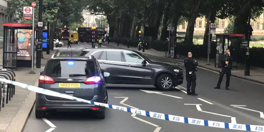 Grossbritannien, London: Polizisten sperren eine Strasse ab, nachdem ein Auto vor dem Parlament in eine Sicherheitsabsperrung gefahren ist und dabei mehrere Fussgänger verletzt hat.