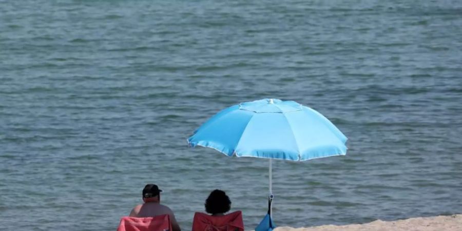 Urlauber geniessen das warme Sommerwetter. Foto: Bernd Wüstneck/dpa