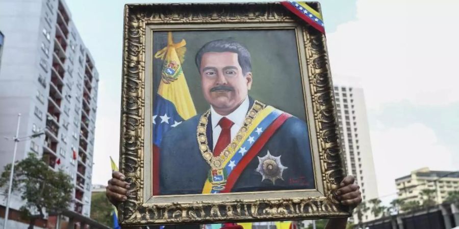 Ein Anhänger von Maduro mit einem Porträt des venezolanischen Präsidenten. Foto: Pedro Mattey