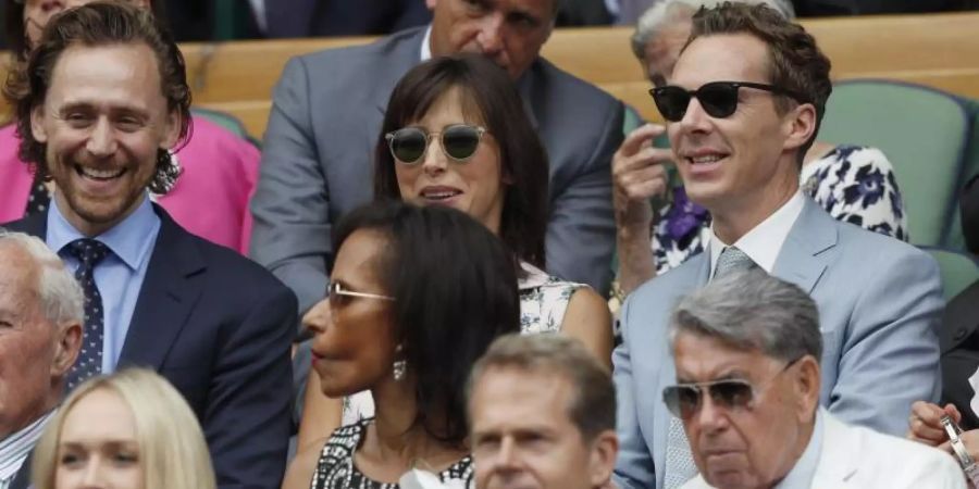 Benedict Cumberbatch (r) sieht sich mit seiner Frau Sophie Hunter das Wimbledon-Finale an. Mit dabei ist auch Schauspiel-Kollege Tom Hiddleston (l). Foto: Adrian Dennis/POOL AFP/AP