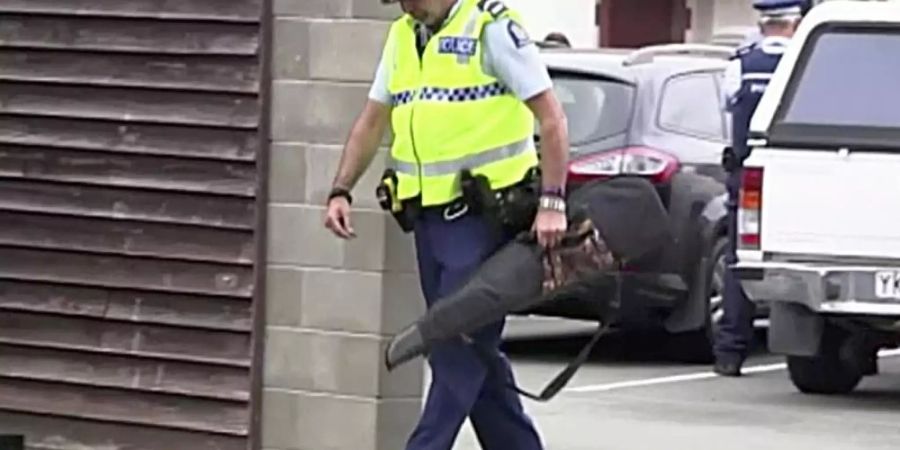 Videostandbild eines Polizisten, der eine Waffe trägt, die von einem Bürger freiwillig in einer Polizeistation abgegeben wurde. Neuseeland verbietet nach dem rassistisch motivierten Anschlag auf zwei Moscheen Sturmgewehre und halbautomatische Waffen. Foto: TVNZ/AP/dpa