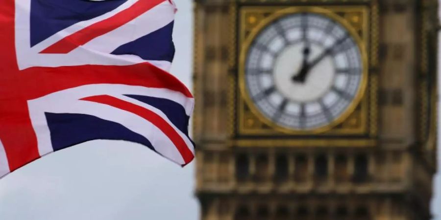 Eine britische Nationalflagge, der Union Jack, weht vor dem Uhrturm Big Ben. Foto: Michael Kappeler