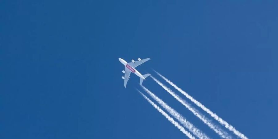 Ein Passagierflugzeug zieht Kondensstreifen über den Himmel. Am kommenden Wochenende beginnen die Osterferien in allen grösseren Bundesländern, Hunderttausende Passagiere drängen dann gleichzeitig an die Gates. Foto: Silas Stein