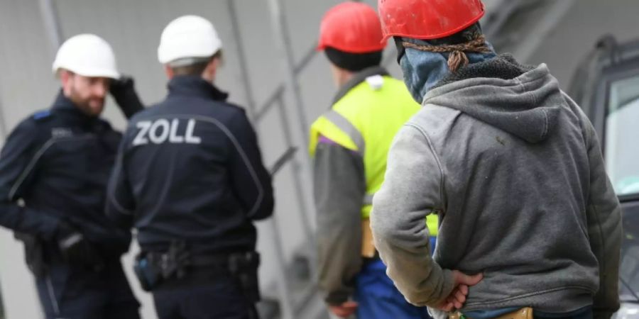 Zollbeamte kontrollieren Bauarbeiter