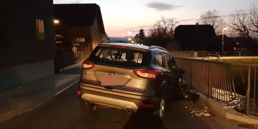 Zerstörtes Auto steht an Brückengeländer
