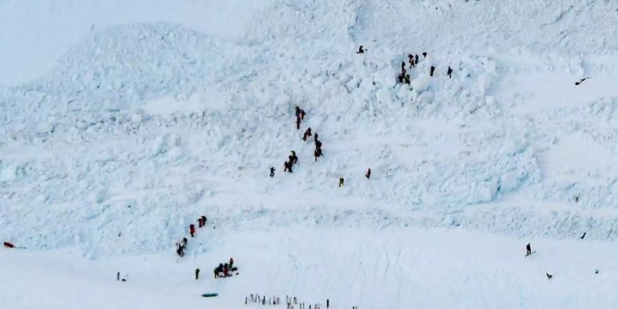 Rettungskräfte sind in einem Lawinengebiet im Skigebiet Crans-Montana im Einsatz. Foto: Anthony Anex/KEYSTONE