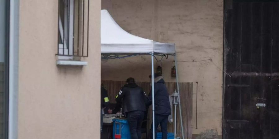 Beamte der Kriminalpolizei sichern im Hinterhof eines Hauses sichergestellte Asservate. Foto: Boris Roessler